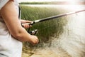 Female hands holding a fishing rod and twist the handle Royalty Free Stock Photo