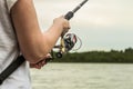 Female hands holding a fishing rod and twist the handle Royalty Free Stock Photo