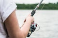 Female hands holding a fishing rod and twist the handle Royalty Free Stock Photo