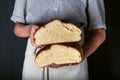 Female hands holding freshly baked sourdough artisan bread sliced in halfs. Homemade with wheat flour and starter. Royalty Free Stock Photo