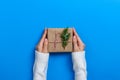 Female hands holding gift box on Blue background