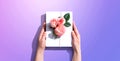 Female hands holding a gift box with pink roses Royalty Free Stock Photo