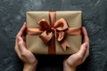 female hands holding gift with brown ribbon. ai generated