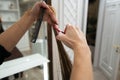 Female hands holding hairbrush and scissors and cutting long hair Royalty Free Stock Photo