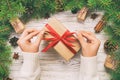 Female hands holding handmade present box in recycled paper on white wooden table background. christmas preparation concept, Gift