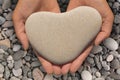 Female hands holding a heart-shaped stone Royalty Free Stock Photo