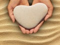 Female hands holding a heart-shaped stone Royalty Free Stock Photo