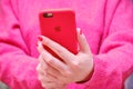 Female hands holding the iphone Apple in a red case. The girl holds the phone and takes a selfie photo Royalty Free Stock Photo