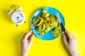 Female hands holding knife and fork on plate with measuring tapes on light background Royalty Free Stock Photo