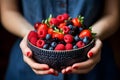 Woman holding large bowl of berries