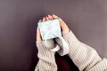 female hands holding light blue gift box with white ribbon on dark grey background. My hands cradle a pastel blue gift box Royalty Free Stock Photo