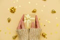 Female hands holding merry christmas gift box on yellow decorated holiday Royalty Free Stock Photo