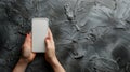 Female hands holding a modern smartphone with a blank screen on a black background Royalty Free Stock Photo