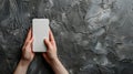 Female hands holding a modern smartphone with a blank screen on a black background Royalty Free Stock Photo