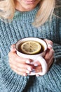 Female hands holding mug of hot tea with lemon in morning. Young woman relaxing tea cup on hand Royalty Free Stock Photo