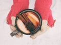Female hands holding mug of mulled wine with apple and spices. Cup of seasonal hot drink. Homemade fruit tea. Royalty Free Stock Photo