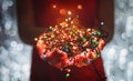 Female hands holding Multicolored Christmas light decorations on dark holiday background. Xmas and New Year theme.