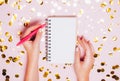 Female hands holding notebook with empt copy space on festive confetti background