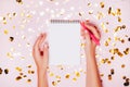 Female hands holding notebook with empt copy space on festive confetti background