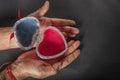 Female hands holding open heart shaped jewelry box on black background Royalty Free Stock Photo