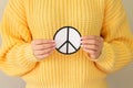 Female hands holding paper peace symbol. Freedom, love and peace concept