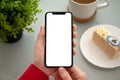 Female hands holding phone with isolated screen in a cafe Royalty Free Stock Photo