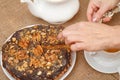 Female hands holding a piece of homemade chocolate cake with silver cake shovel