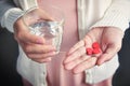 Female is holding red pills in heart shape. Royalty Free Stock Photo