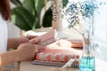 Female hands holding pink coral coloured leather diary 2021 while sitting near a window at cafe