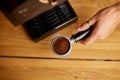 Male barista hand making espresso from ground coffee maker at modern cafe Royalty Free Stock Photo