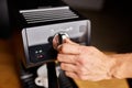 Male barista hand making espresso from ground coffee maker at modern cafe Royalty Free Stock Photo