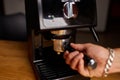 Male barista hand making espresso from ground coffee maker at modern cafe Royalty Free Stock Photo