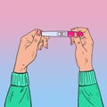 Female Hands Holding Positive Pregnancy Test with Two Red Stripes