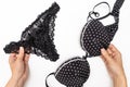 Female hands holding set of black woman underwear, sexual lacy bra and panties on white background Royalty Free Stock Photo