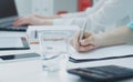 Female hands holding a silver pen. Business woman making notes at office workplace. Business job offer, financial Royalty Free Stock Photo