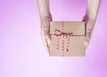 Female hands holding a simple craft paper gift box wrapped Royalty Free Stock Photo