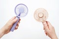 Female hands holding small fans on white background close-up. Royalty Free Stock Photo