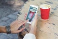 Female hands holding smartphone and shooting coffee.