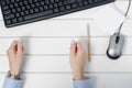 Female hands holding something to hold notes on a keyboard mouse from a computer Royalty Free Stock Photo