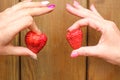 Female hands holding strawberries on a wooden background Royalty Free Stock Photo