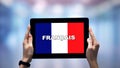 Female Hands Holding Tablet With French Word Against National Flag, Online App