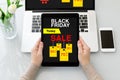 Female hands holding tablet with sale black friday screen