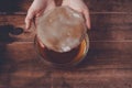 Female hands holding tea mushroom in glass jar on wooden background. Preparing kombucha.
