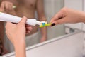 Female hands holding a toothbrush and placing toothpaste on it Royalty Free Stock Photo