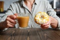 Female hands holding transparent cup of coffee and donut in a white glaze with yellow confectionery sprinkles on a kitchen Royalty Free Stock Photo