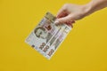 Female hands holding Ukrainian banknotes on yellow background Royalty Free Stock Photo