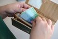 Female hands holding ukrainian hryvnia bills in small money pouch or wallet