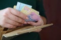 Female hands holding ukrainian hryvnia bills in small money pouch or wallet Royalty Free Stock Photo