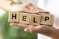 Female hands holding wooden cubes, blocks word HELP. Conceptual image about human rights, education, social issues Royalty Free Stock Photo