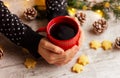 female hands hug a red cup with a hot drink on a table with cookies and cones. winter holidays, Christmas, New Year Royalty Free Stock Photo